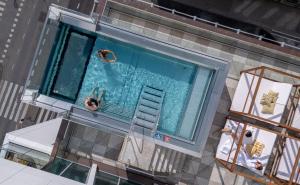 two people swimming in a swimming pool on a building at Willow, WorldHotels Crafted in Trelleborg