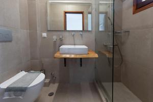 a bathroom with a toilet and a sink and a shower at Alkyoni Forest Rooms in Skala