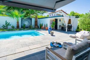 a patio with a swimming pool and a house at Chambre D'hôtes Villa Menta in Arbonne