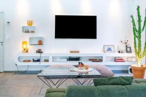 a living room with a tv on a white wall at Chambre D'hôtes Villa Menta in Arbonne