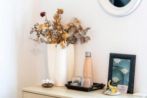 a table with a vase and a shelf with a flower at Chambre D'hôtes Villa Menta in Arbonne +15 photos