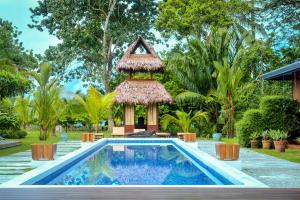 a swimming pool in a backyard with a gazebo at Blue Osa Beach Resort & Spa in Puerto Jiménez