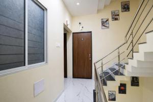 a hallway with stairs and a wooden door at Via Mannat in Indore
