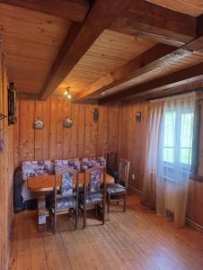 a dining room with a wooden table and chairs at Котедж Арніка з Чаном in Vorokhta
