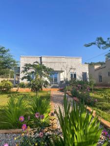a garden in front of a building with flowers at Akagera Able Lodge in Akagera