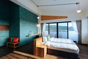 a bedroom with a large bed with a green accent wall at Chillax Inn B&B 恆春鬆塊民宿 in Hengchun +86 photos