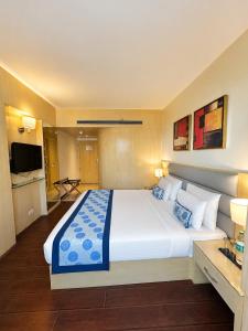 a hotel room with a large bed and a television at The Theme, Jaipur in Jaipur +56 photos
