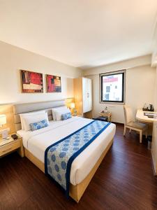 a hotel room with a large bed and a desk at The Theme, Jaipur in Jaipur