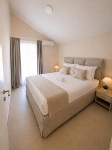 a bedroom with a large white bed with a window at Monte Aria panorama suites in Herceg-Novi