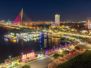 a city lit up at night with boats in the water at Grand Mercure Danang - 10 minutes to Airport & 200m to Bach Dang Walking street in Danang