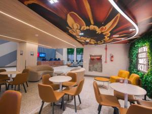 a waiting room with tables and chairs and a ceiling at ibis Curitiba Shopping in Curitiba