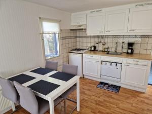 a kitchen with white cabinets and a table and chairs at Watercabin in Ooltgensplaat in Ooltgensplaat