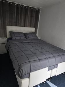 a bedroom with a large bed with a blue comforter at Watercabin in Ooltgensplaat in Ooltgensplaat