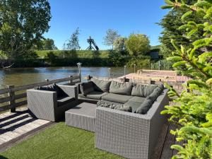 two couches sitting on a deck next to a river at Watercabin in Ooltgensplaat in Ooltgensplaat