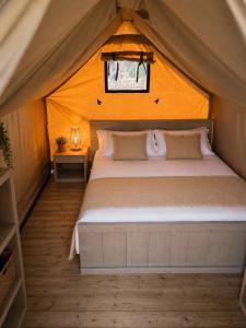 a bedroom with a bed in a tent at Camping Derby Loredo by Mola! in Loredo