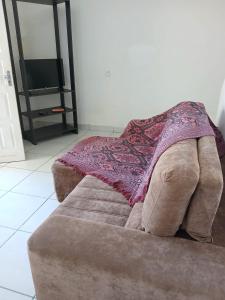 a blanket on the back of a couch in a living room at Casa ampla vila nova de colares in Serra