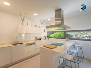 a kitchen with white cabinets and a large window at Villa Cata in Esporles