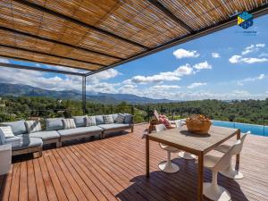 a patio with a couch and a table on a deck at Villa Cata in Esporles