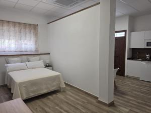 a bedroom with a bed in a white room at Loft Plaza in Hornachuelos