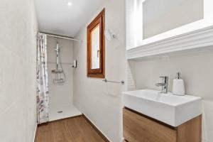 a white bathroom with a sink and a shower at Villa Casa Para Ti in El Tosalet