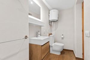 a white bathroom with a toilet and a sink at Villa Casa Para Ti in El Tosalet