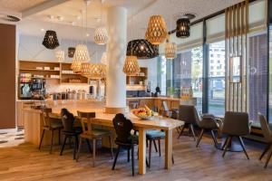 a kitchen with a table and chairs and a bar at Citadines Arnulfpark Munich in Munich