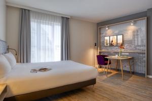 a hotel room with a bed and a table at Citadines Arnulfpark Munich in Munich +27 photos