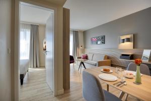 a room with a dining table and a living room at Citadines Arnulfpark Munich in Munich