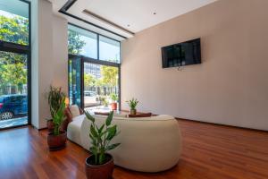 a living room with a white couch and potted plants at 3B Suites Boutique Hotel in Sarandë