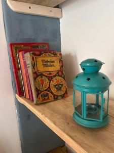 a table with a book and a lantern on a shelf at Danube Atelier - The Garden in Rossatz