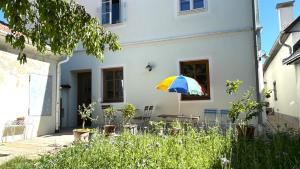 a colorful umbrella in front of a white house at Danube Atelier - The Garden in Rossatz