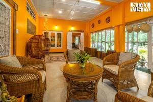 a living room with chairs and a table at StayVista at The Sahib's Bungalow with BBQ & Bonfire in Kālchīni