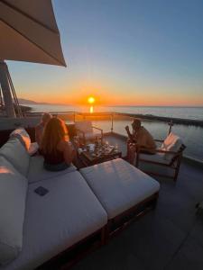 a group of people sitting on a boat watching the sunset at Oceanview Vega in Sisi