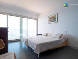 a bedroom with a large bed and large windows at Villa Sa Troneta in Cala Pi +34 photos