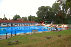 a large swimming pool with a slide and a playground at Apartmán Eva in Crhov