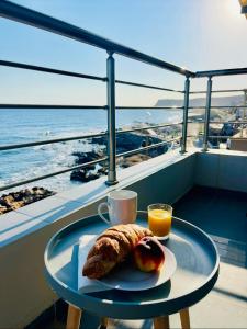 a table with a plate of food and a cup of orange juice at Oceanview Vega in Sisi