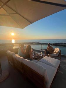 a group of people sitting on a balcony watching the sunset at Oceanview Vega in Sisi +7 photos