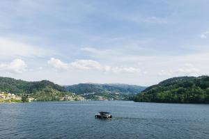 a boat in the middle of a large lake at Douro Royal Valley Hotel & Spa in Riba Douro