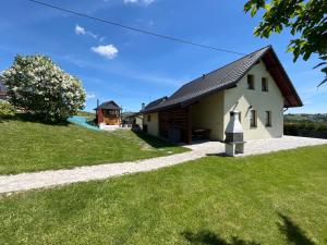 a house with a green lawn and a pathway at Domki pod Beskidem in Jaworzynka