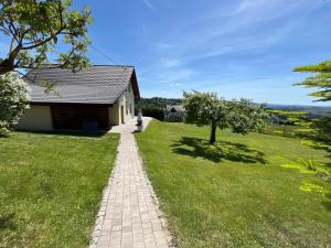 a brick path leading to a house with a grass yard at Domki pod Beskidem in Jaworzynka