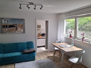 a living room with a blue couch and a table at Miramar in Dahme