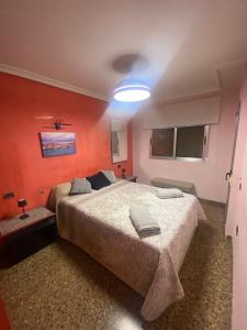 a bedroom with a large bed with orange walls at Ca La Solé in Vinarós