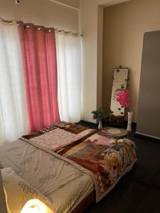 a bedroom with a bed with curtains and a mirror at The Heritage Homes in Mysore