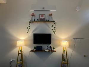 a room with two lamps and a television on a wall at The Heritage Homes in Mysore