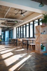 a large room with tables and chairs and windows at Chillax Inn B&B in Hengchun South Gate