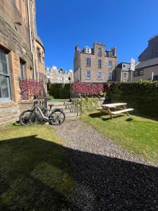 a bike parked next to a building with a picnic table at West End Beds in Dundee