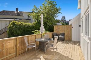 a patio with a table and chairs and an umbrella at Hagehuset in Kragerø +6 photos