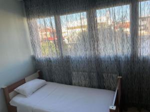 a bedroom with a bed and a large window at mema apartment in Nea Peramos