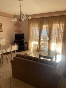a living room with a couch and a table at mema apartment in Nea Peramos