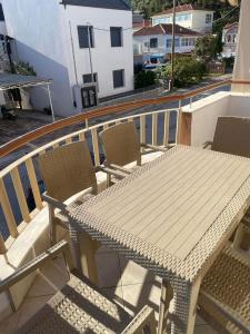 a wooden table and chairs on a balcony at mema apartment in Nea Peramos